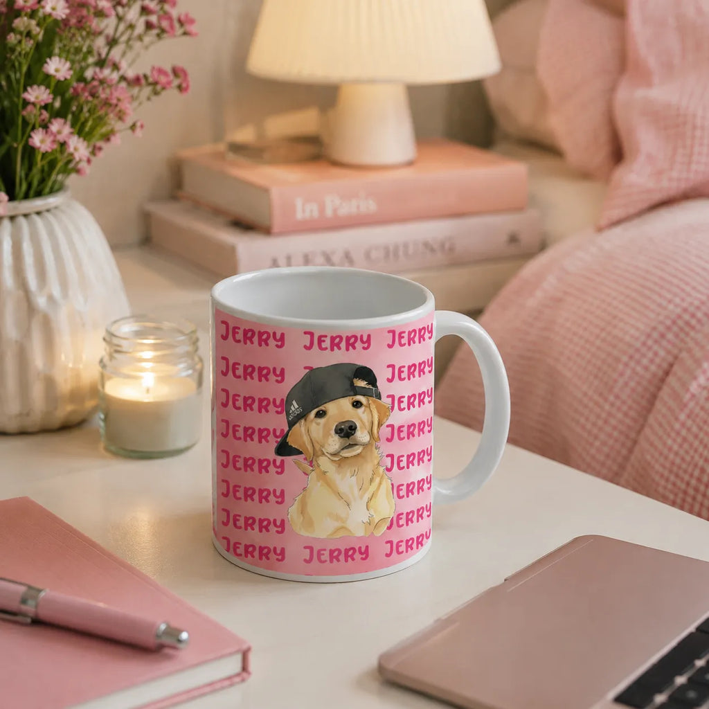 A white ceramic mug with a pink background pattern of the word 'JERRY' and a central illustration of a golden retriever wearing a black cap, styled on a bedside table in a cozy bedroom setting.